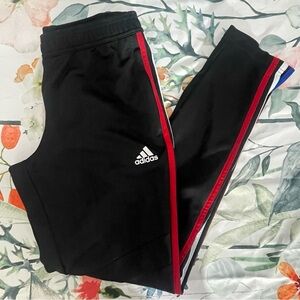 Adidas track pants with red, white, and blue stripes